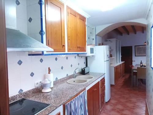 a kitchen with a sink and a white refrigerator at SOTIO, Village house in Campanet in Campanet
