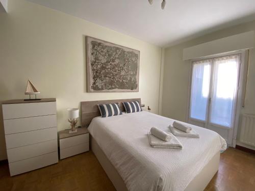 una camera da letto con un letto e due asciugamani di KAIOA .Incluye parking privado. a Hondarribia
