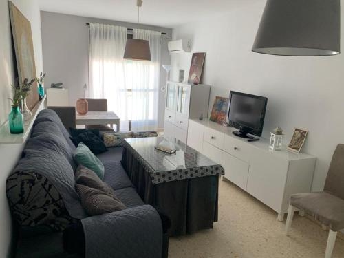 a living room with a couch and a table and a tv at Apartamento Al Andalus in Baena