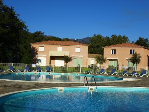 - une piscine avec des chaises en face d'une maison dans l'établissement Villa Fior 50, à Santa-Maria-Poggio