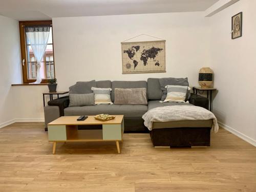 ein Wohnzimmer mit einem Sofa und einem Couchtisch in der Unterkunft LA RUELLE ALSACIENNE, Charme Alsacien et Confort Moderne in Riquewihr