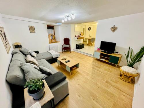 ein Wohnzimmer mit einem Sofa und einem Tisch in der Unterkunft LA RUELLE ALSACIENNE, Charme Alsacien et Confort Moderne in Riquewihr