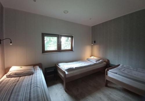 Zimmer mit 2 Betten und einem Fenster in der Unterkunft Farma Jantar in Jantar