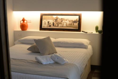 a bedroom with a bed with a picture on the wall at BORGANTHIA in Alberobello