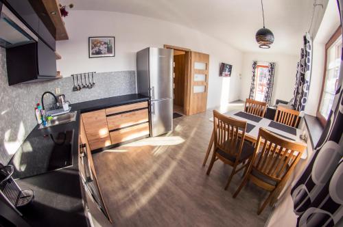 a kitchen with a refrigerator and a table with chairs at Apartmán Benecko 213 in Benecko
