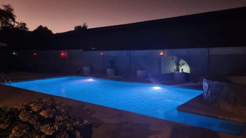 una piscina iluminada por la noche en Apart Hotel Antu de Villarrica, en Villarrica