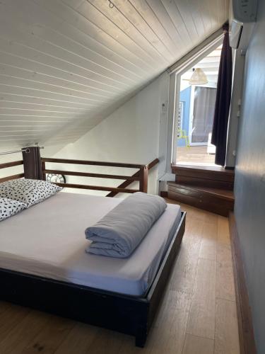 a large bed in a room with a window at Duplex Côté Mer in Filaos