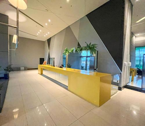 eine Lobby mit einer gelben Theke mit Pflanzen darauf in der Unterkunft Paiva (Barra Home Stay) Luxuoso - vista incrível 26 andar in Recife