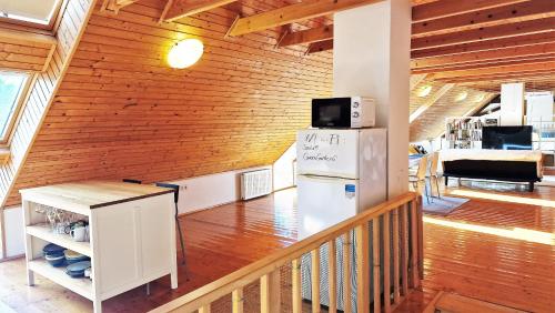 a kitchen with a refrigerator and a microwave at Garden Apartment Szolad - Balaton in Szólád