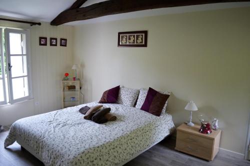 ein Schlafzimmer mit einem Bett mit einem Teddybär drauf in der Unterkunft L'ESCALE DES 2 EAUX in Mortagne-sur-Sèvre
