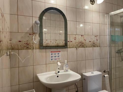 La salle de bains est pourvue d'un lavabo, d'un miroir et de toilettes. dans l'établissement Agroturystyka pod Wieżą, à Chojna