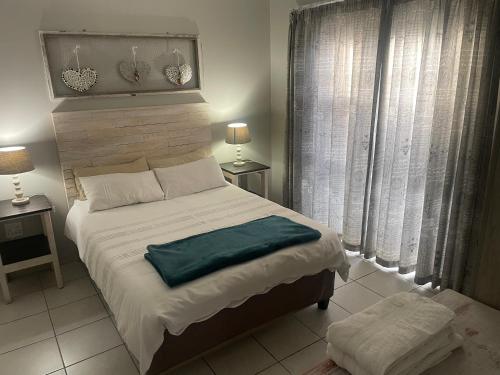 a bedroom with a large bed and two windows at Anas Inn in Walvis Bay