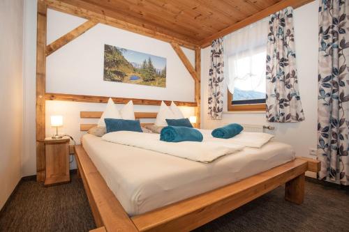 a bedroom with a large white bed with blue pillows at Gästehaus Fuchs in Gröbming
