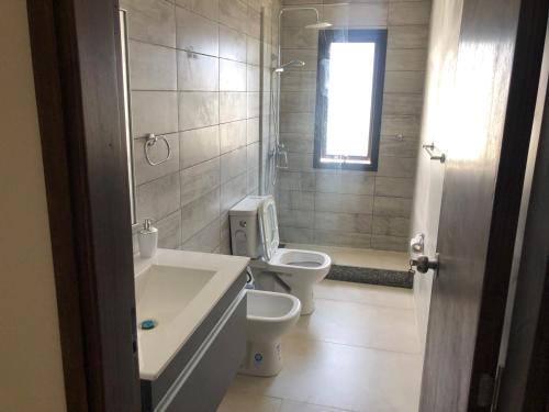 uma casa de banho com 2 WC, um lavatório e uma banheira em Apartamento céntrico 3 Edificio picazzo en Mercedes Uruguay em Mercedes