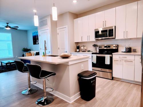 a kitchen with white cabinets and a island with bar stools at Short term rental in Charlotte