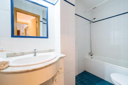 bagno bianco con lavandino e specchio di Distinguido y céntrico apartamento en San Bernardo a Siviglia