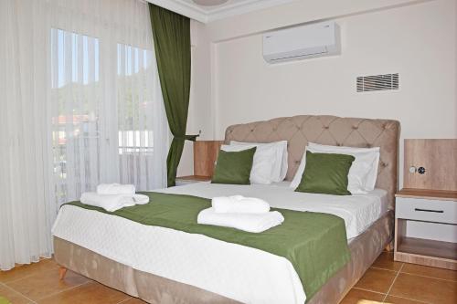 sypialnia z dużym łóżkiem z ręcznikami w obiekcie Villa Brezza w mieście Fethiye