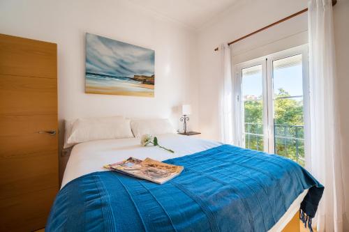 um quarto com uma cama com um cobertor azul e uma janela em Distinguido y céntrico apartamento en San Bernardo em Sevilha