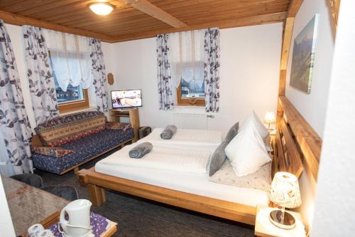 a small room with a bed and a couch at Gästehaus Fuchs in Gröbming