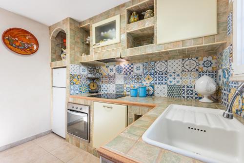 een keuken met een spoelbak en een aanrechtblad bij Casa vacanza - Le Mennule in Alliste