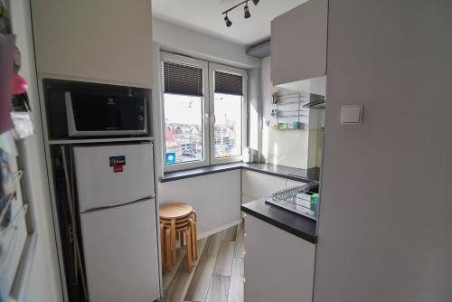 a small kitchen with a refrigerator and a window at Beautiful view in Gdańsk