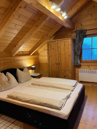 a bedroom with a large bed in a wooden room at Berg Chalet 303 in Turracher Hohe