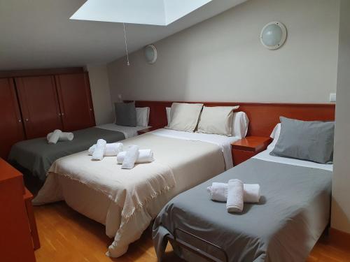 a room with two beds with white towels on them at Hotel Villa De Lerma in Lerma