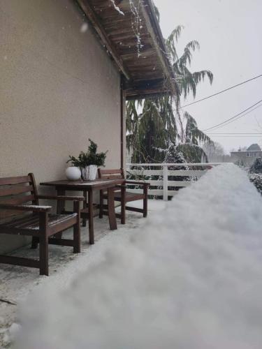 a snow covered porch with benches and a table at dom w Junoszynie in Junoszyno