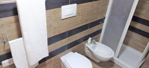 a bathroom with a white toilet and a sink at Napoletando b&b in Naples