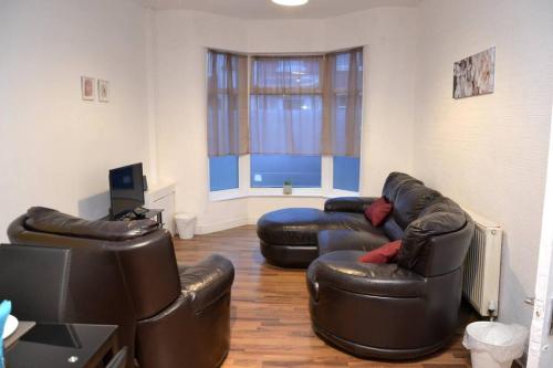 a living room with two leather couches and a window at Cozy home near city, sleeps 5, Free Parking, WIFI in Liverpool