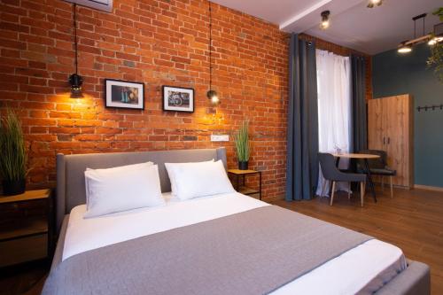a bedroom with a bed and a brick wall at New studio in the city center – Kharkivska naberezhna 3 in Kharkiv
