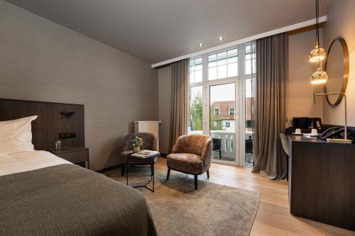 a hotel room with a bed and a desk and chair at Hotel Britannia in Knokke-Heist