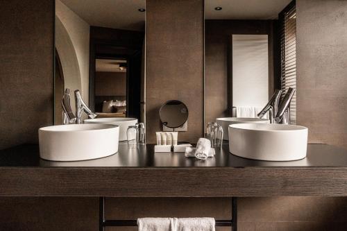 a bathroom with two sinks and two mirrors at Hotel Britannia in Knokke-Heist