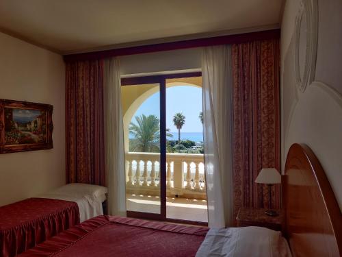 Camera d'albergo con vista su un balcone di Parco dei Principi Hotel a Roccella Ionica