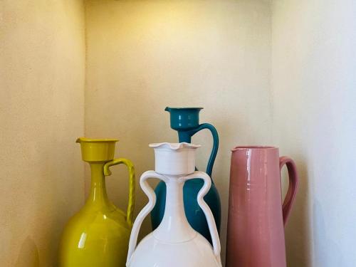 three different colored vases sitting on a shelf at Masseria Messapia Wine Resort & Spa Salento in Mesagne