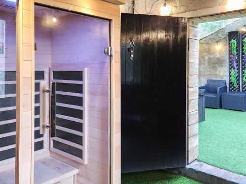 a door to a sauna with a green floor at Riverside Cottage in Larkhall