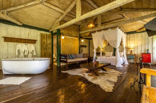 uma grande sala com uma banheira e um quarto em Pousada Meu Recanto em Conceição da Ibitipoca