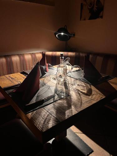 a wooden table with a lamp and glasses on it at Hotel Rio Bianco in Panchia