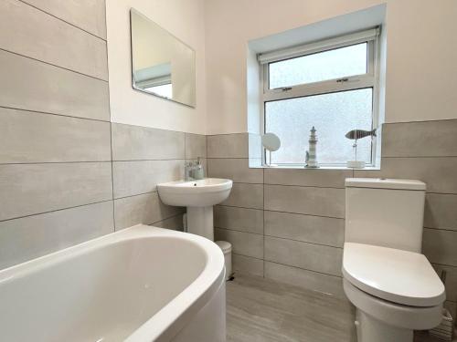 een badkamer met een bad, een wastafel en een toilet bij Riverside Cottage in Wetherby