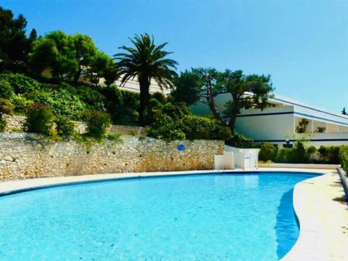 une grande piscine avec deux chaises et un bâtiment dans l'établissement VUE MER EXCEPTIONNELLE - GRANDE TERRASSE et PISCINE, à Bandol