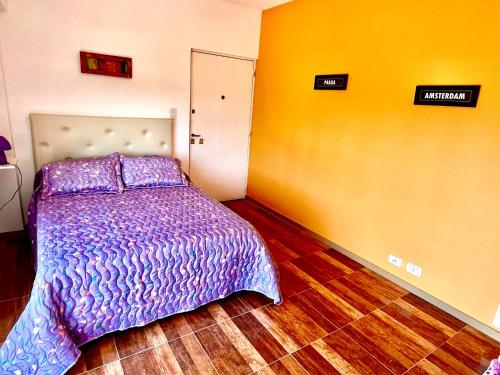 Un dormitorio con una cama con un edredón morado. en Excelente monoambiente en Buenos Aires
