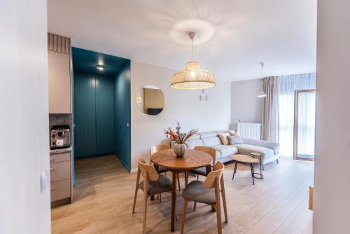 a living room with a table and a couch at Apartament Let's Sea A19 Gąski in Gąski