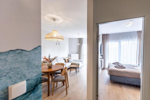 ein Schlafzimmer und ein Wohnzimmer mit einem Bett und einem Tisch in der Unterkunft Apartament Let's Sea A19 Gąski in Gąski