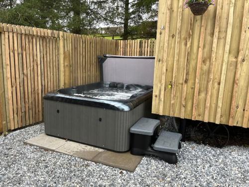 a hot tub sitting next to a wooden fence at Ramblers retreat in Shrewsbury