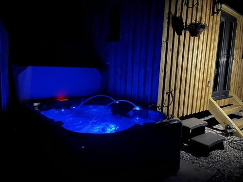 a dark room with a jacuzzi tub with blue lighting at Ramblers retreat in Shrewsbury