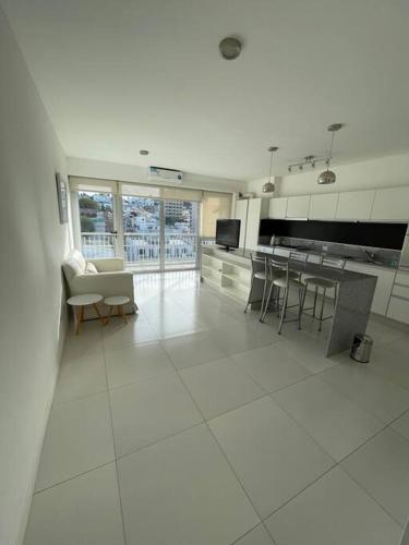 una gran cocina blanca con mesa y sillas en Moderno departamento de 52 mts en el centro en Comodoro Rivadavia