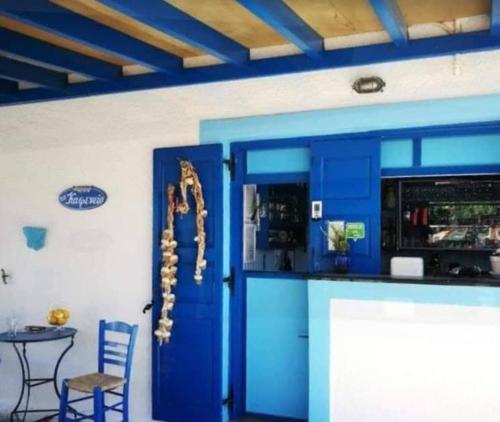 a blue kitchen with a counter and a blue door at Blue Dolphin Studios and Apartment in Vaia