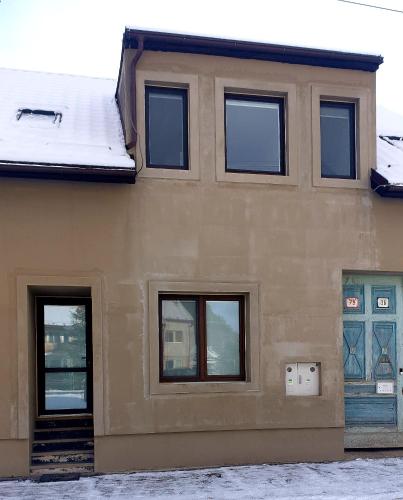 a house with four windows on the side of it at Apartmán Bambuľka in Slovenská ľupča