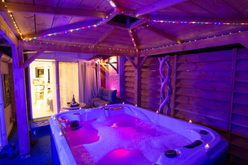 a purple room with a tub with lights on it at Studios avec piscine ou jaccuzi in Velaux