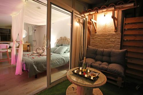 Pokój z łóżkiem, kanapą i stołem w obiekcie Lovina Chambre de charme avec jaccuzi w mieście Velaux